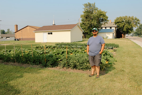 Eric Viall stands next to the Ray community garden that provides for the local food pantry.
Photo by Erica Kingston
